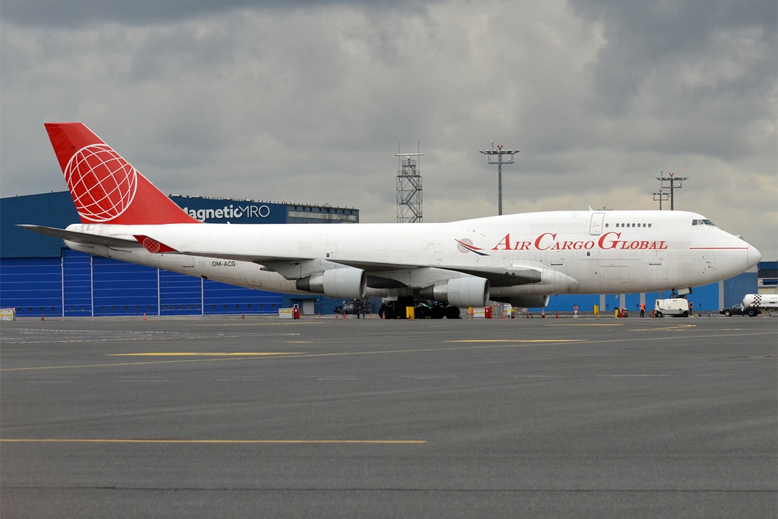 En stor Boeing 747F från Air Cargo Global vid en flygplatsterminal, redo för lastning.